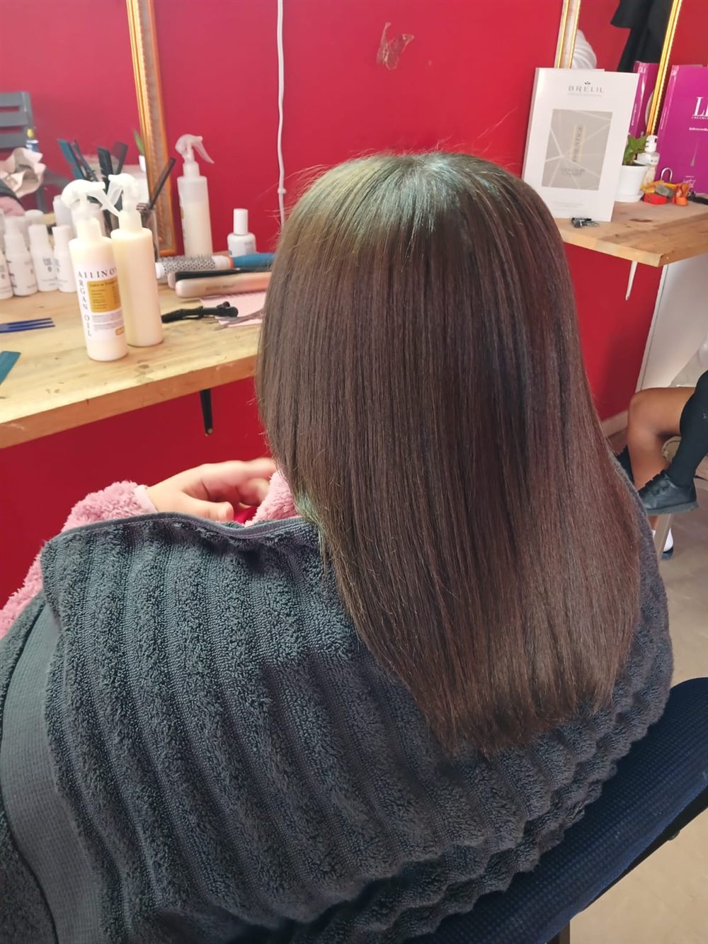 Client's hair being finished at the Hair By Mimmie styling station